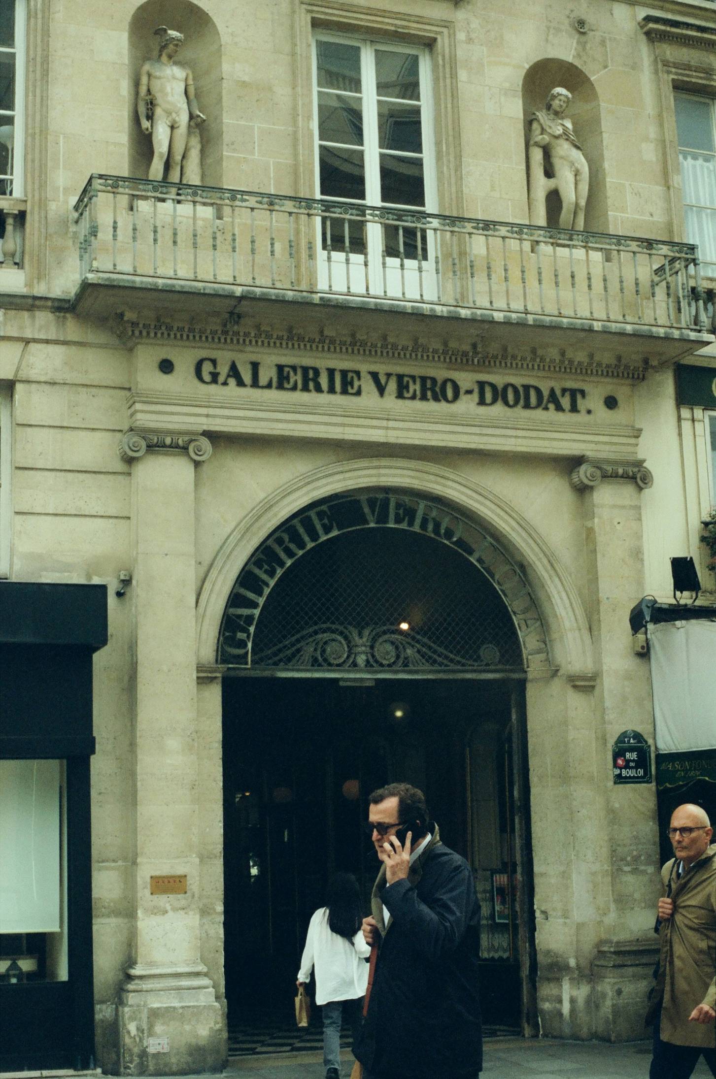 A man talking on a cell phone in front of a building