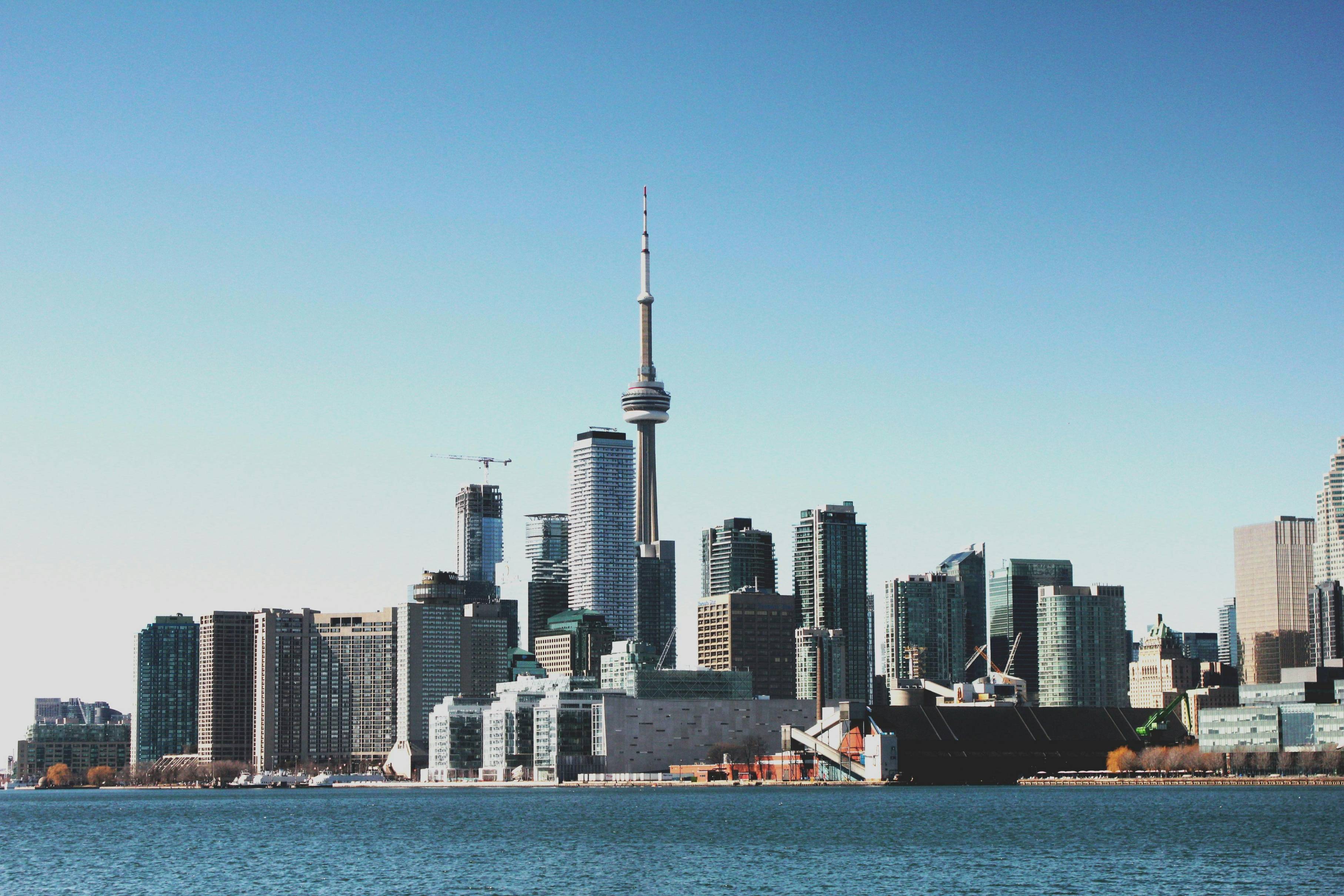 photo of high-rise buildings near body of calm water during daytime