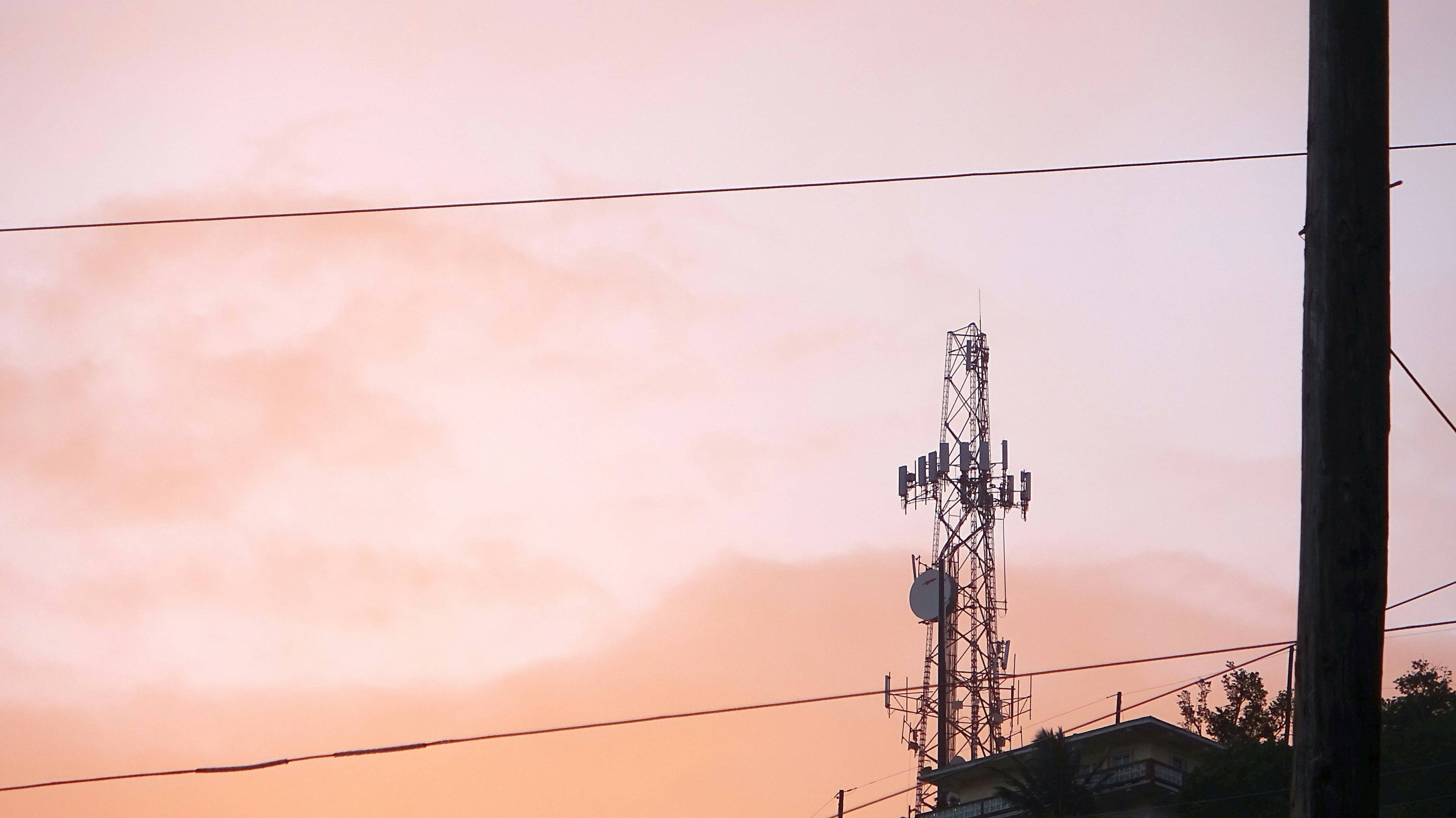 a cell phone tower with a sunset in the background