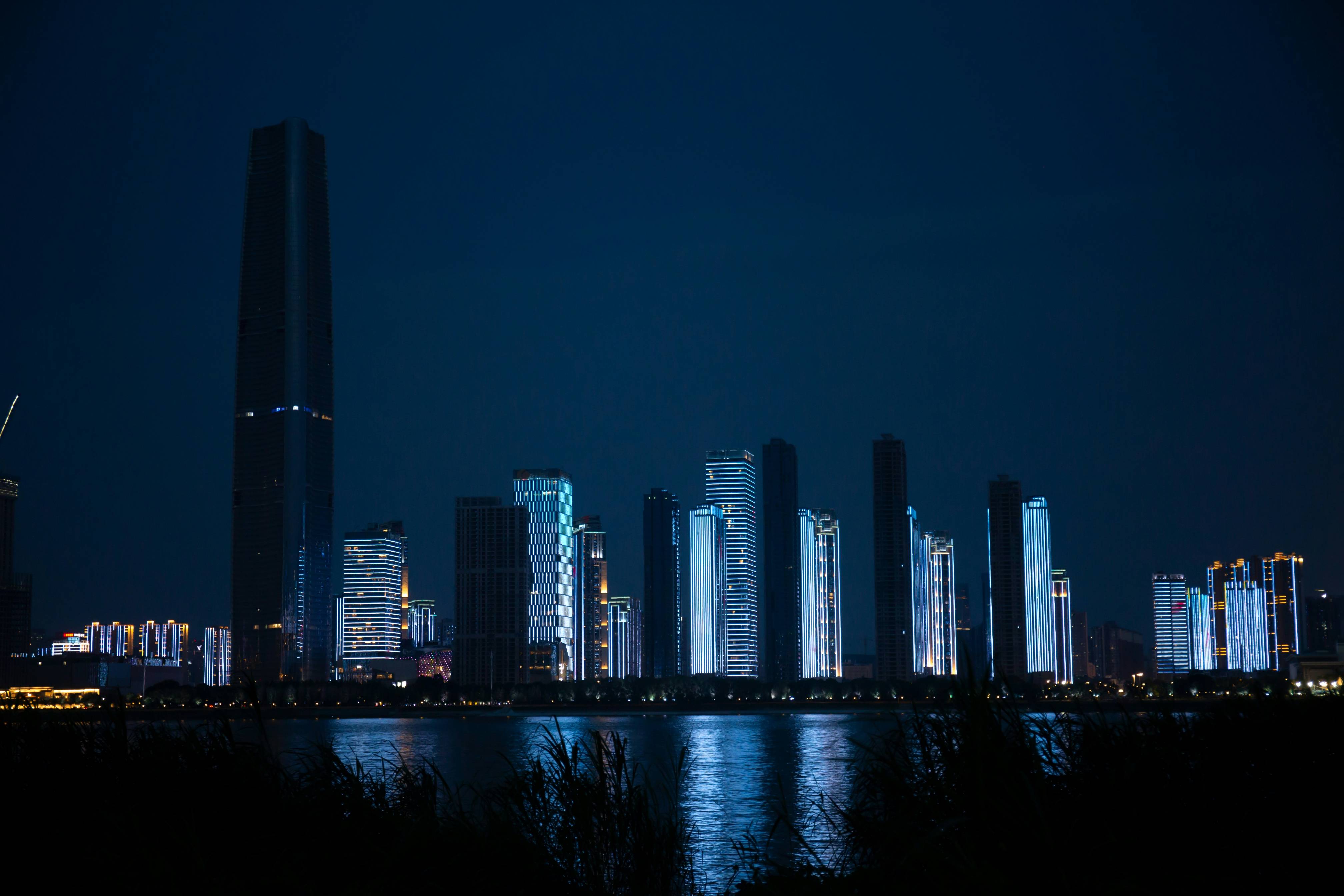 a city at night with a body of water in front of it