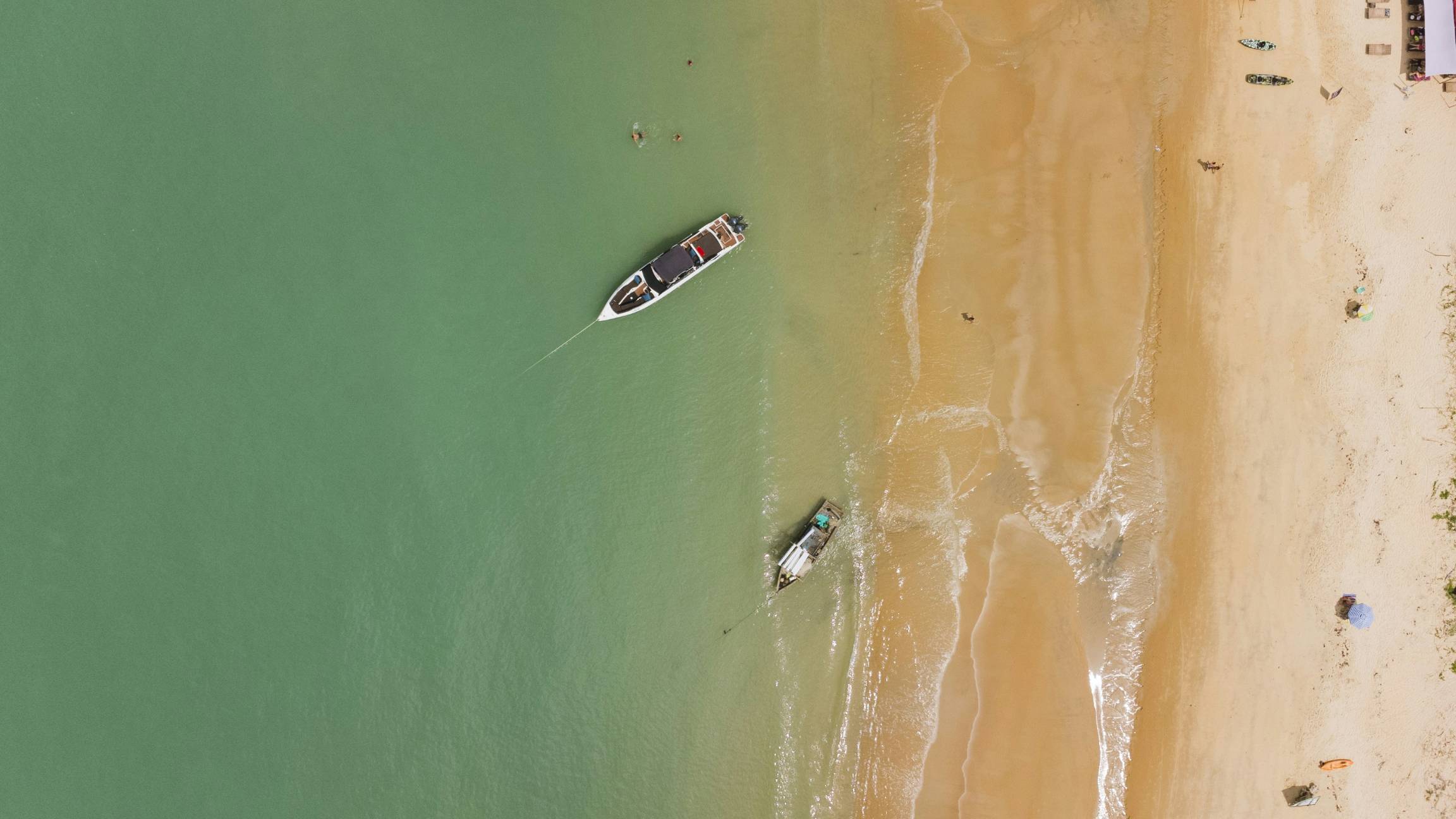 Boats near a beach with turquoise water.