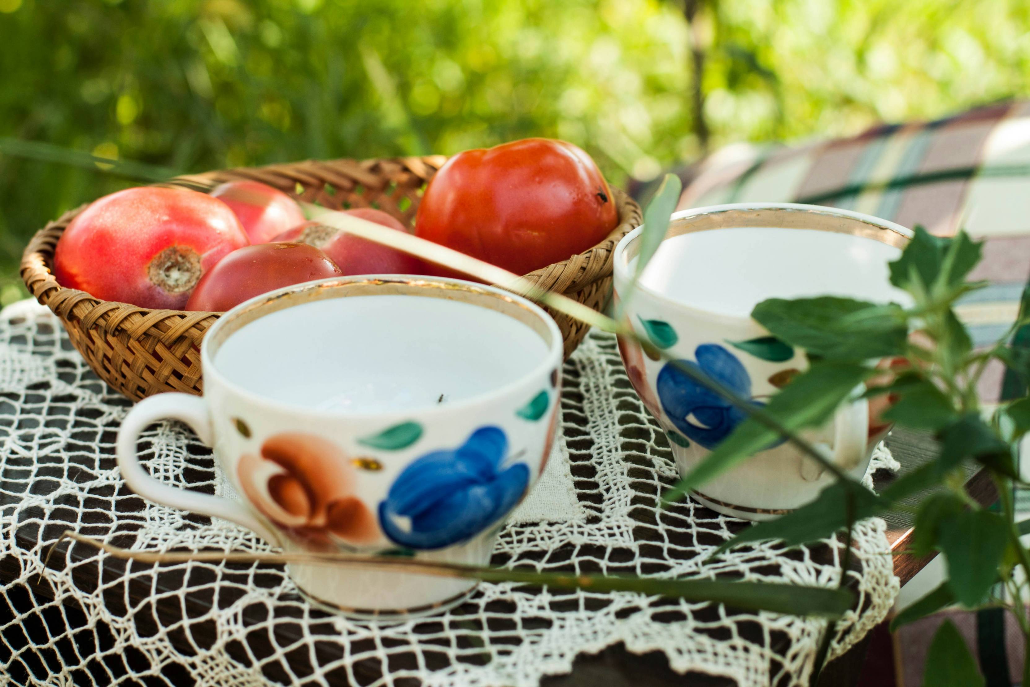 white blue and green floral ceramic teacup on white table cloth