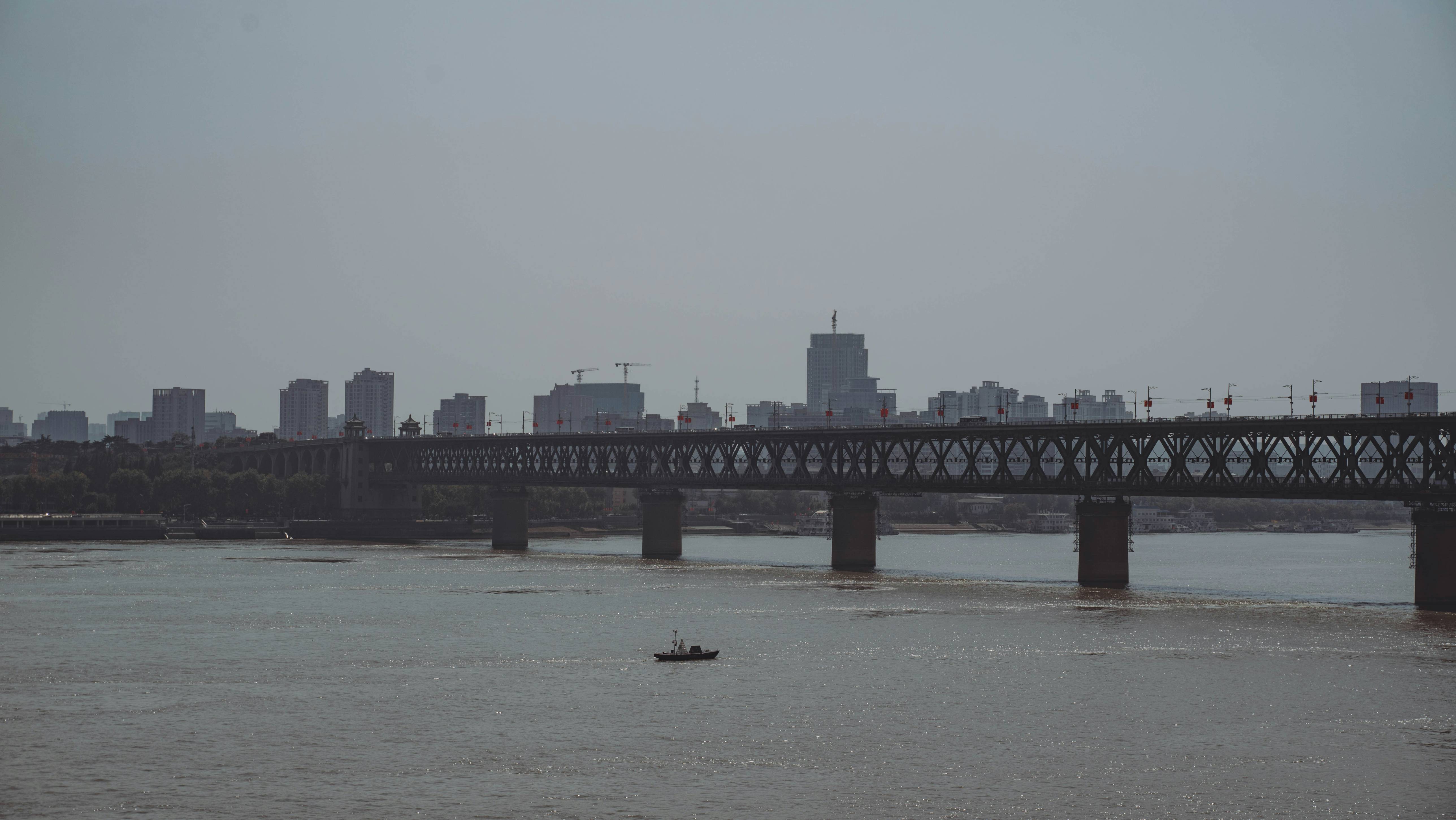 a bridge over a river with a boat in the water