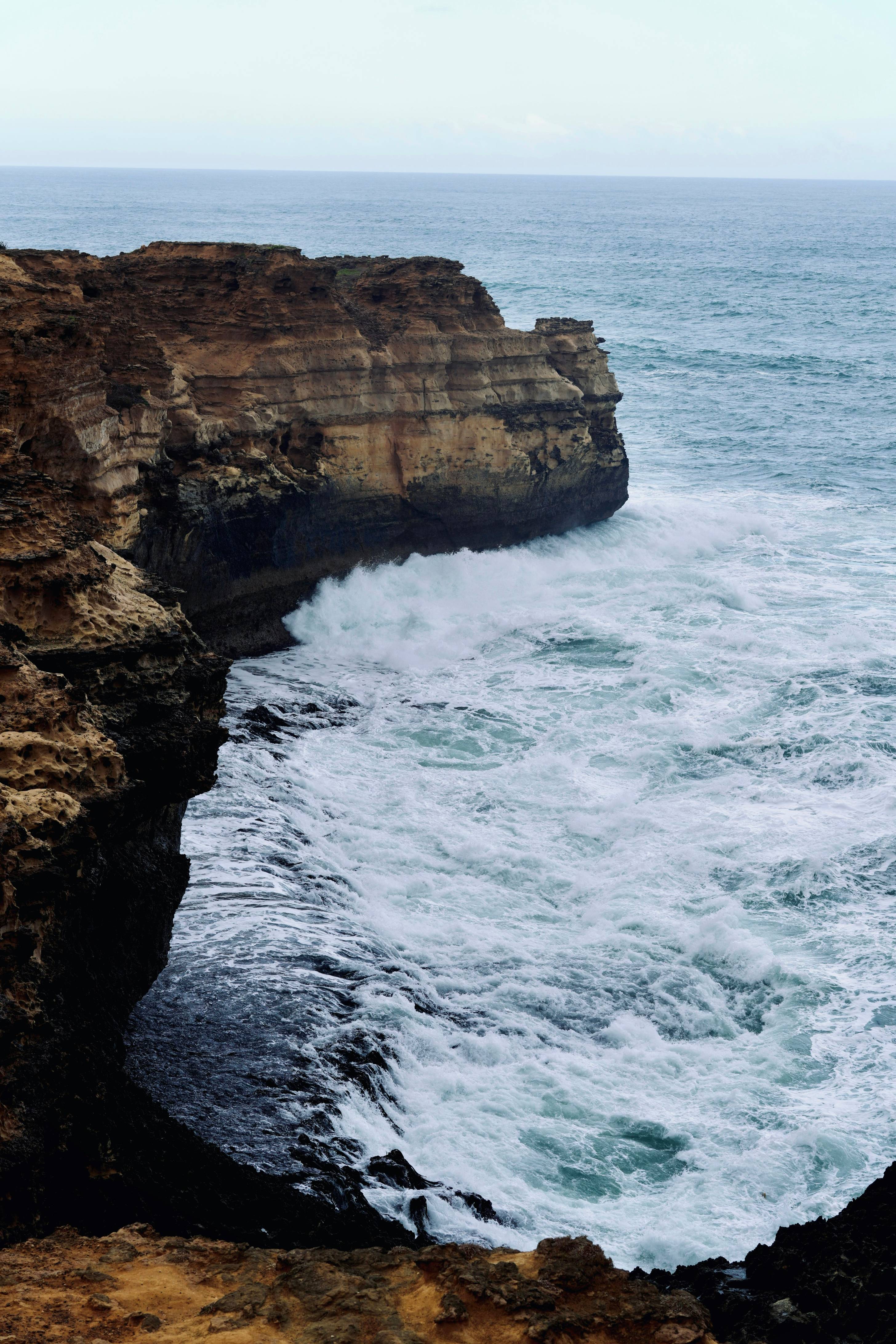 Waves crash against a rocky cliff.